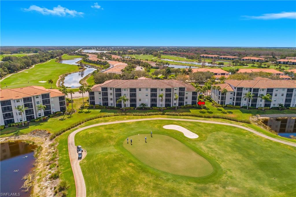 Aerial view of condos beside a golf course, with a red arrow marking a unit.