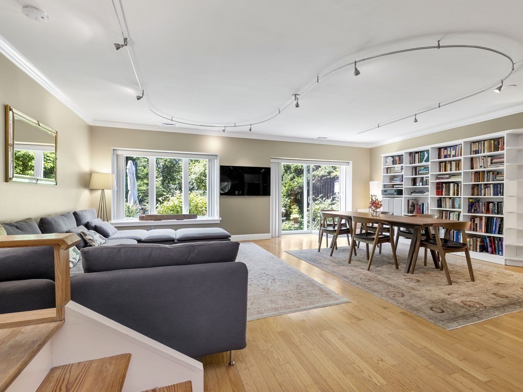 Open-plan living and dining room with built-in bookshelves and sliding doors to the garden.