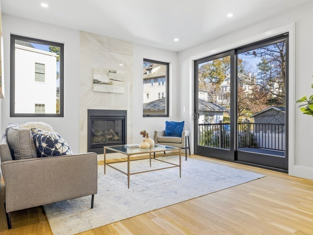 Staged living room with a gas fireplace and sliding glass doors opening to a balcony.