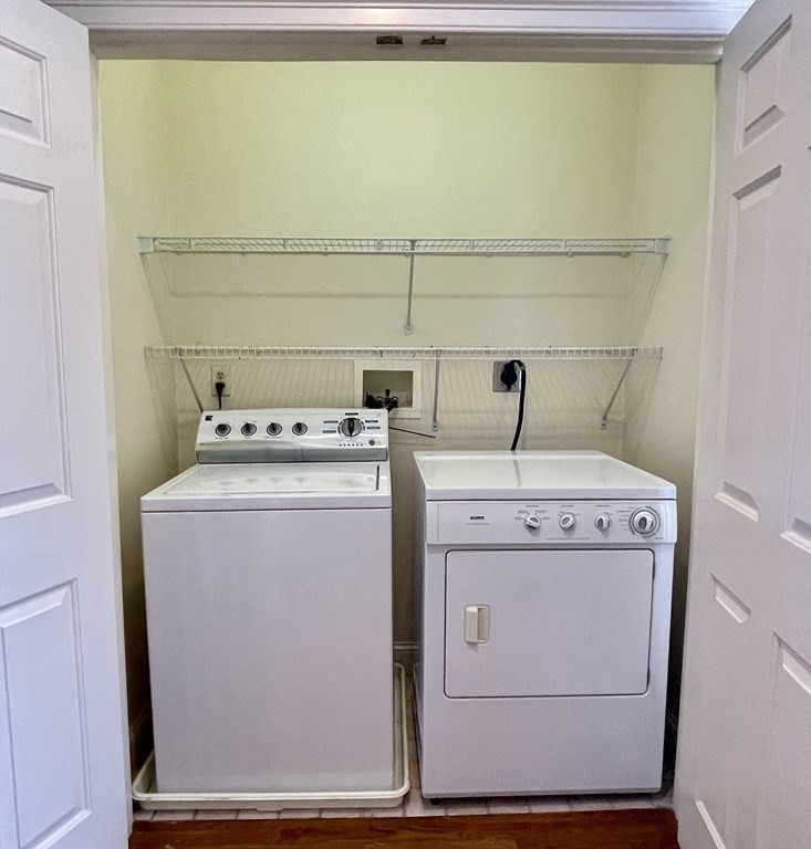 Laundry closet with a top-loading washer, front-loading dryer, and wire shelves.