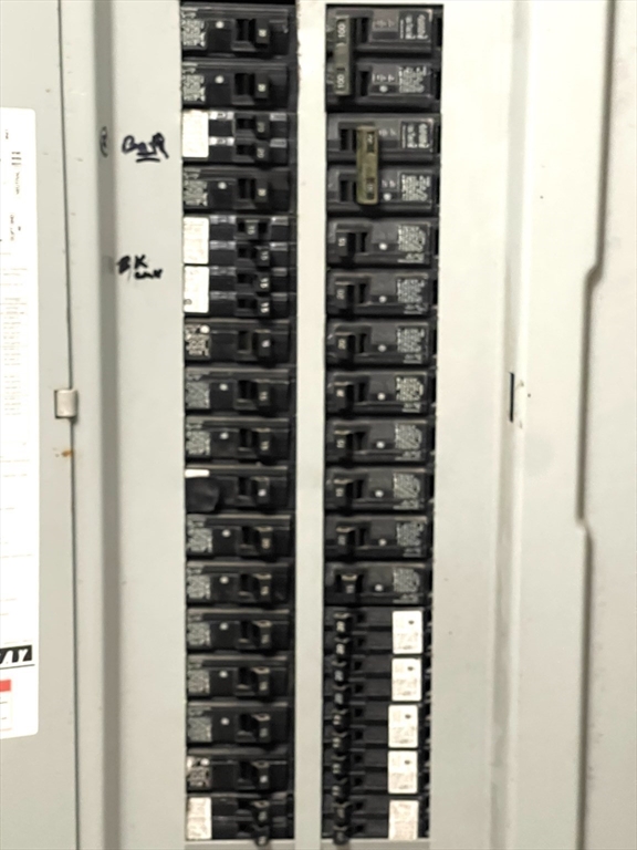 Electrical panel with two columns of circuit breakers and handwritten markings.