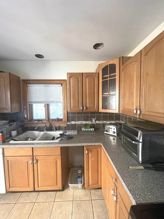 Kitchen with wood cabinets, a double-basin sink, and gray countertops.