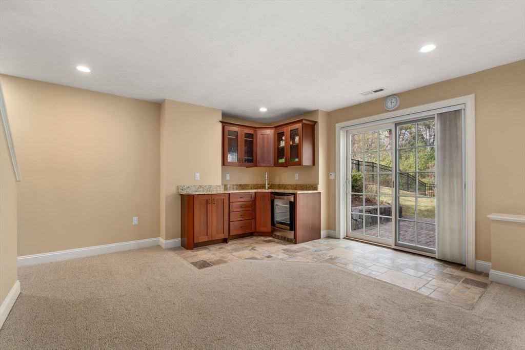 Unfurnished room with a compact wood-cabinet kitchen and sliding glass doors to a patio.