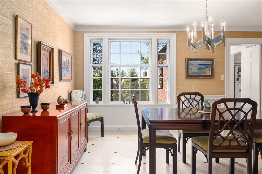 Dining room with a dark wood table, red sideboard, and large multi-pane window.