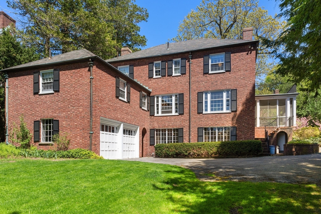Red brick house with black shutters, an attached white garage, and a covered porch.