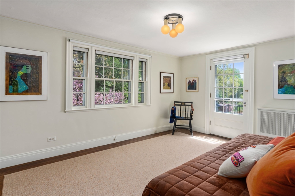 Bedroom with a brown quilted bed, large windows, and a glass door to a balcony.