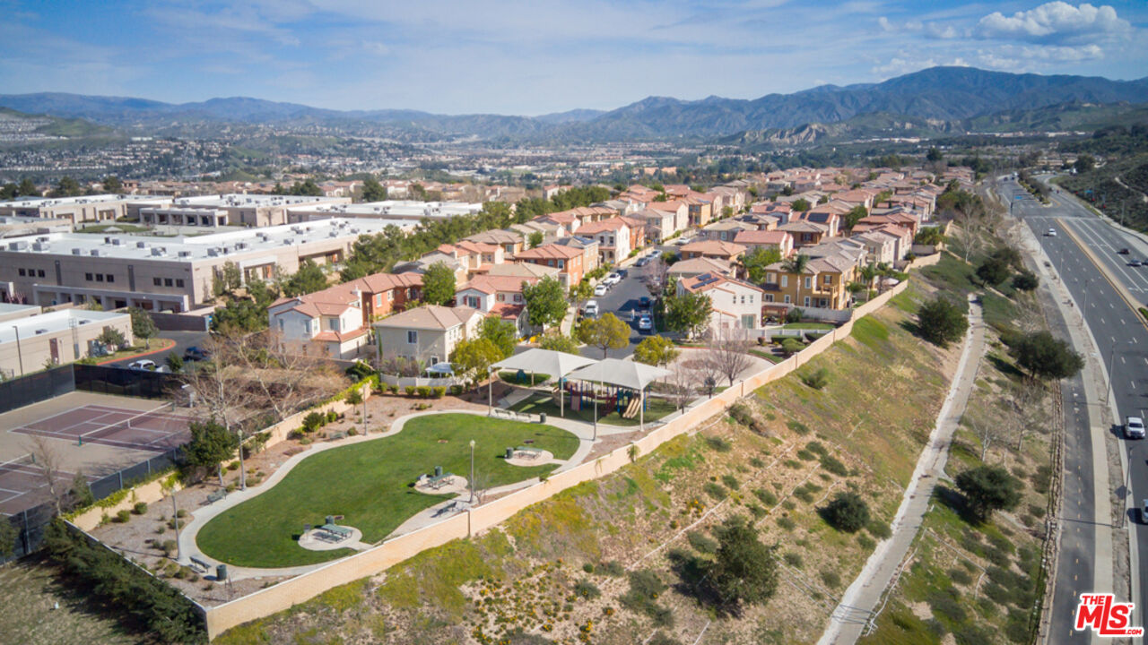 Aerial view of homes and a landscaped park, with mountains beyond the Santa Clarita neighborhood.