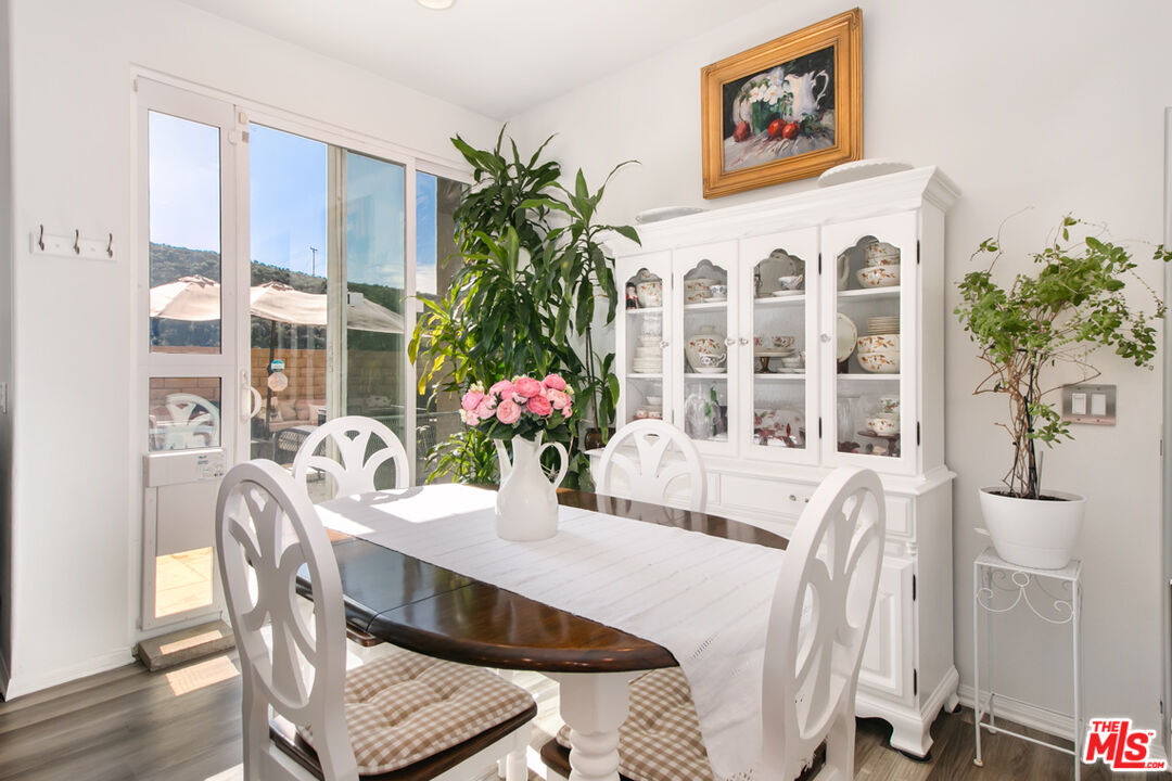 Dining room with a dark oval table, white chairs, and a glass-front china cabinet.