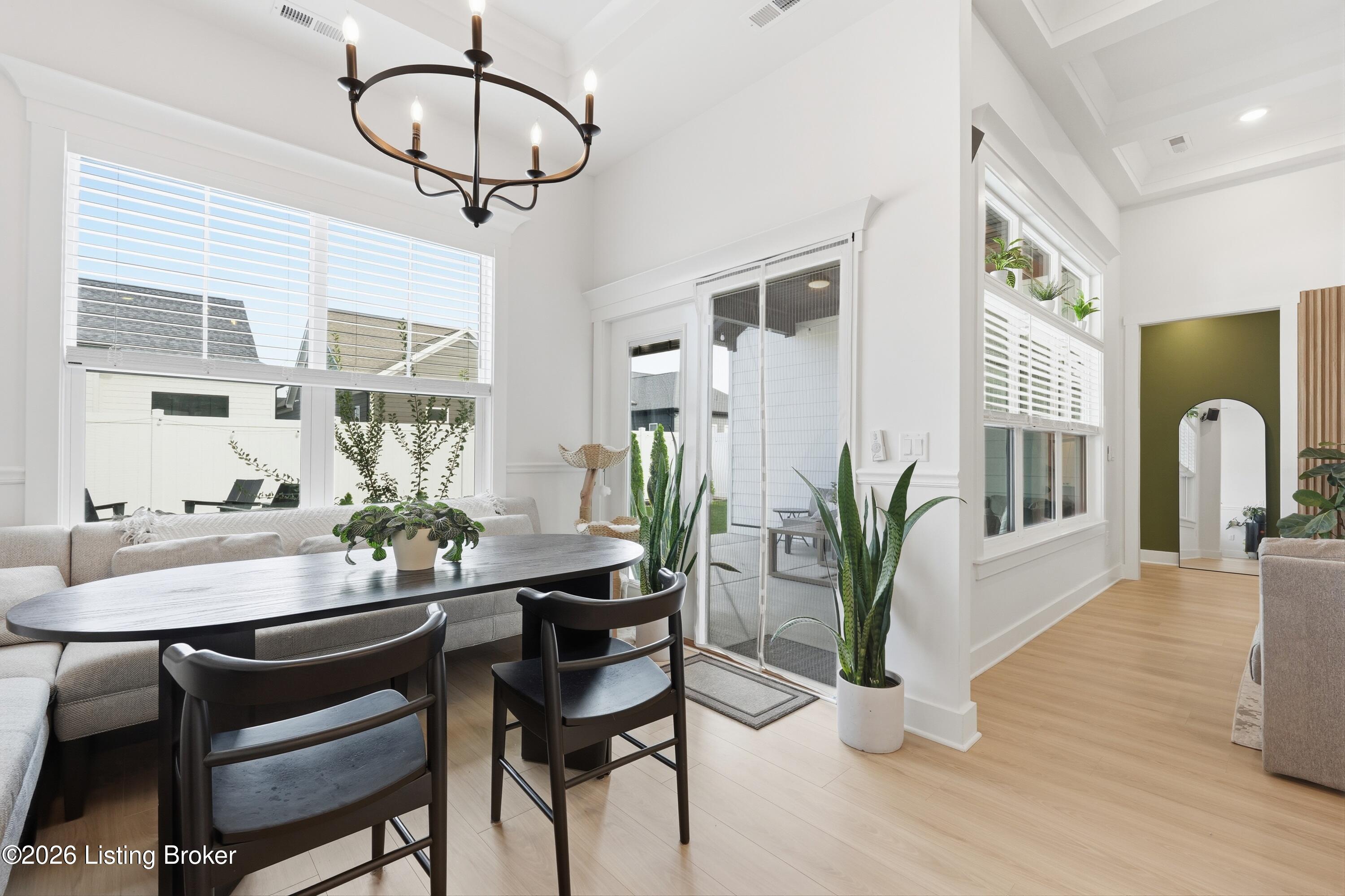Dining area with a dark table, upholstered seating, and a sliding glass door to the patio.