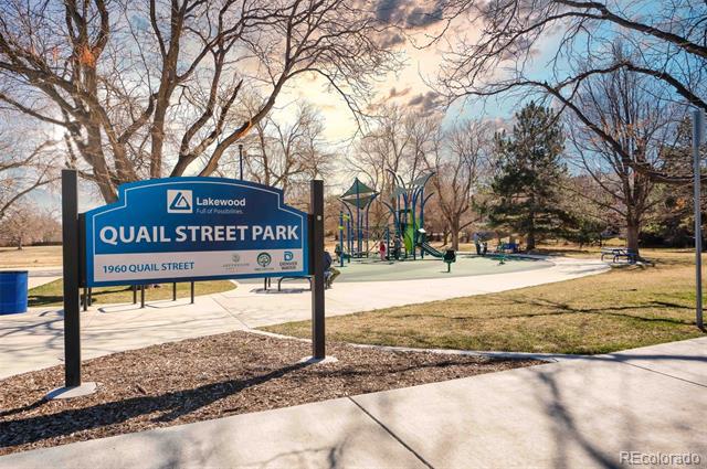 Quail Street Park sign beside a playground and paved paths.