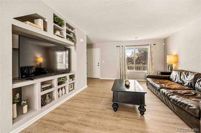 Living room with built-in TV shelving, leather sofa, and black coffee table.