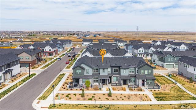 Aerial view of gray attached townhomes, with one building marked by an orange location pin.