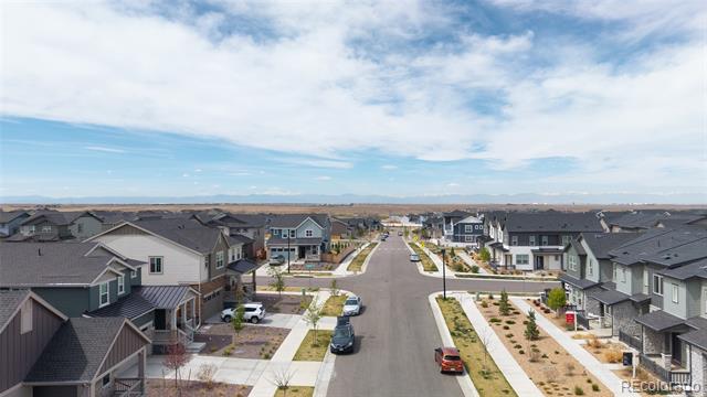 Aerial view of a residential street lined with detached houses and young landscaping.