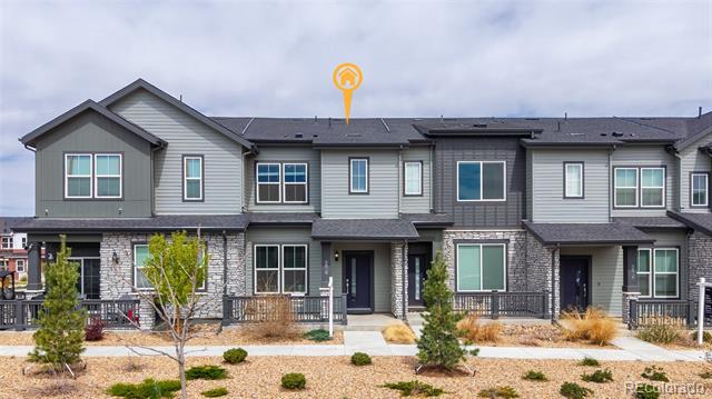 Attached gray townhomes with stone accents and landscaped front beds.