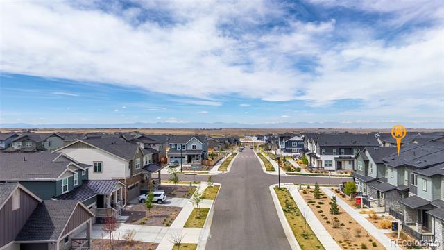 Aerial view down a residential street lined with modern homes and newly landscaped yards.