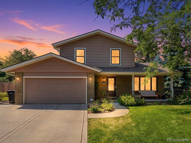 Two-story home with a double garage and landscaped lawn at dusk.