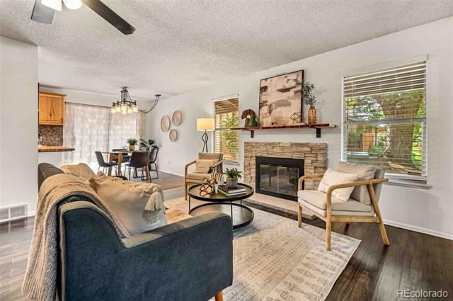 Living room with a stone fireplace, blue sofa, and dining area.