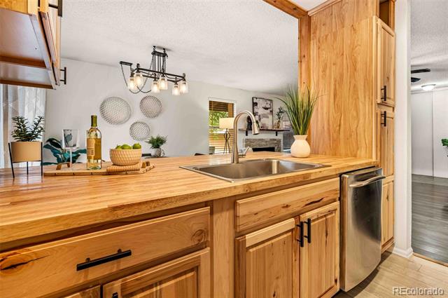 Kitchen with wood cabinets and counters, a stainless-steel sink, and dishwasher.