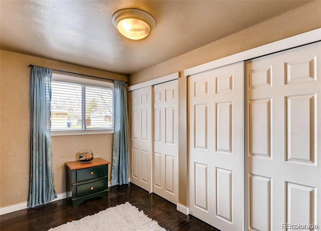 Bedroom with a wall of white paneled closet doors, blue curtains, and a white shag rug.