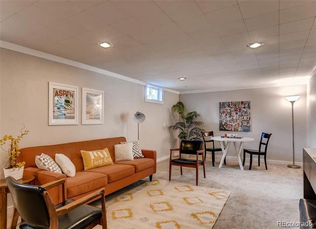 Living area with a rust-colored sofa, patterned rug, and a small dining table.