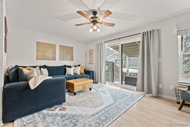 Living room with a dark blue sectional, patterned rug, and sliding doors to a covered patio.
