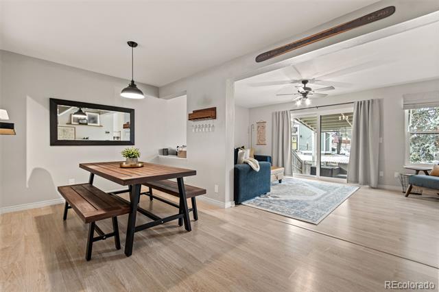 Open dining and living area with a black table, blue sofa, and sliding doors to a covered patio.
