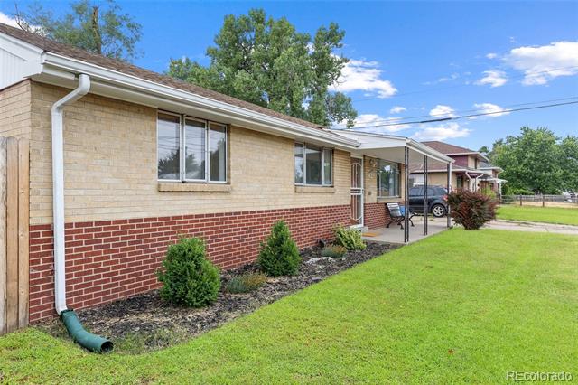 Single-story ranch home with a red brick facade, covered entry, and landscaped lawn.