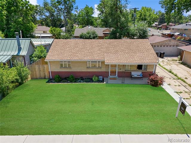 Single-story brick house with a tan roof and broad green front lawn, viewed from above.