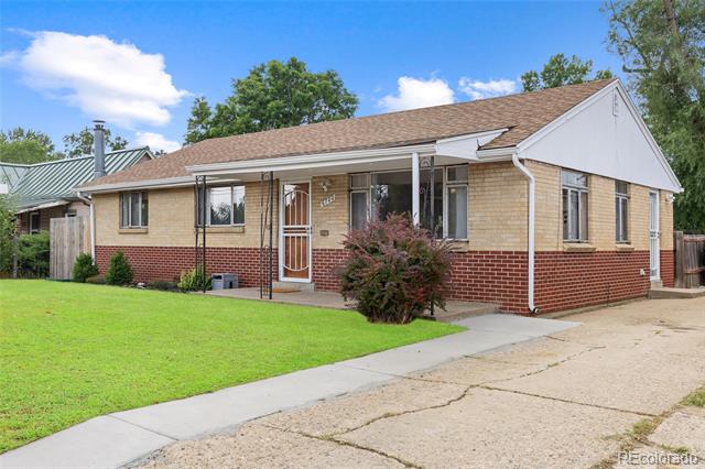 Single-story brick ranch home with a covered porch, green lawn, and concrete driveway.
