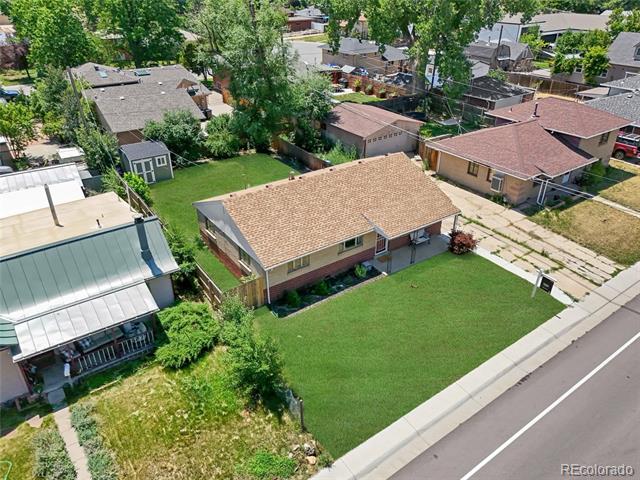 Aerial view of a brick ranch house with a tan roof and broad front lawn.