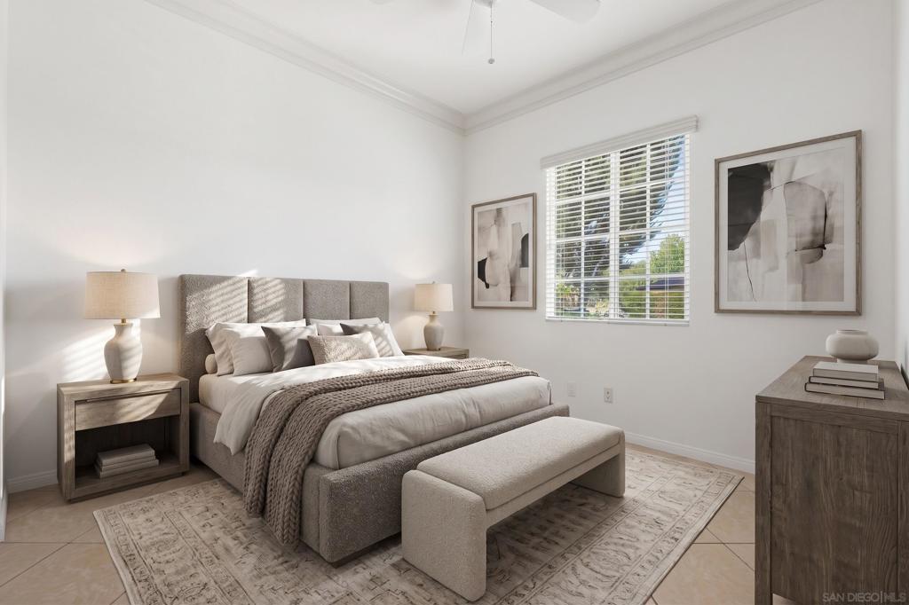 Staged bedroom with a gray upholstered bed, neutral bedding, and a bench beneath abstract artwork.