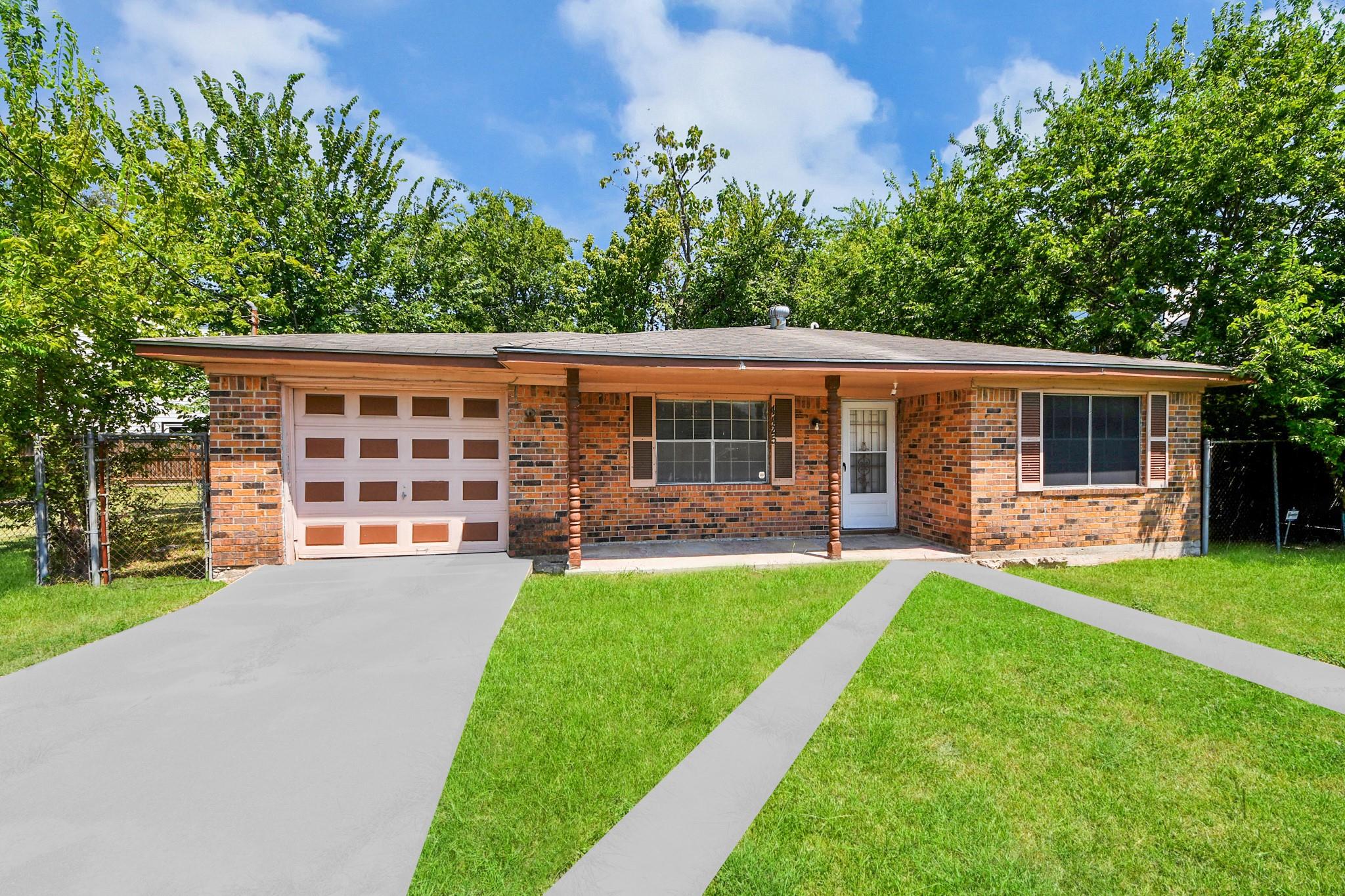 Single-story brick house with an attached garage, covered entry, and broad front lawn.