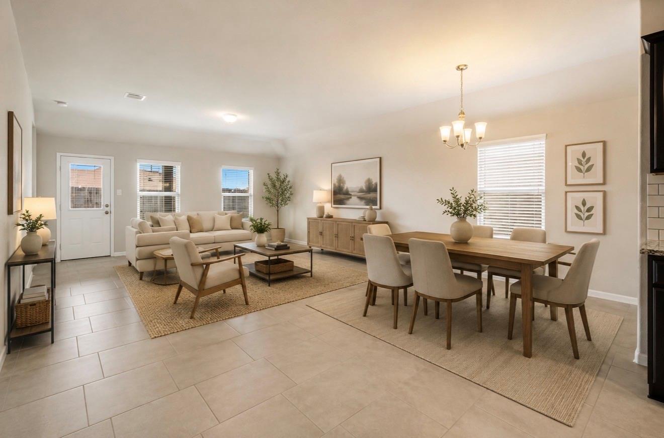 Open-plan living and dining room with a beige sofa, wooden dining table, and tiled floors.
