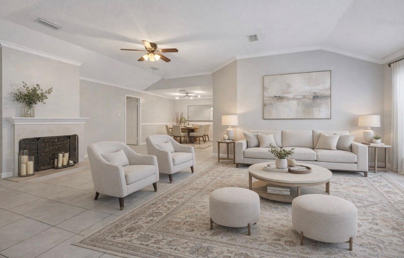 Staged living room with a white sofa, fireplace, and dining area beyond.