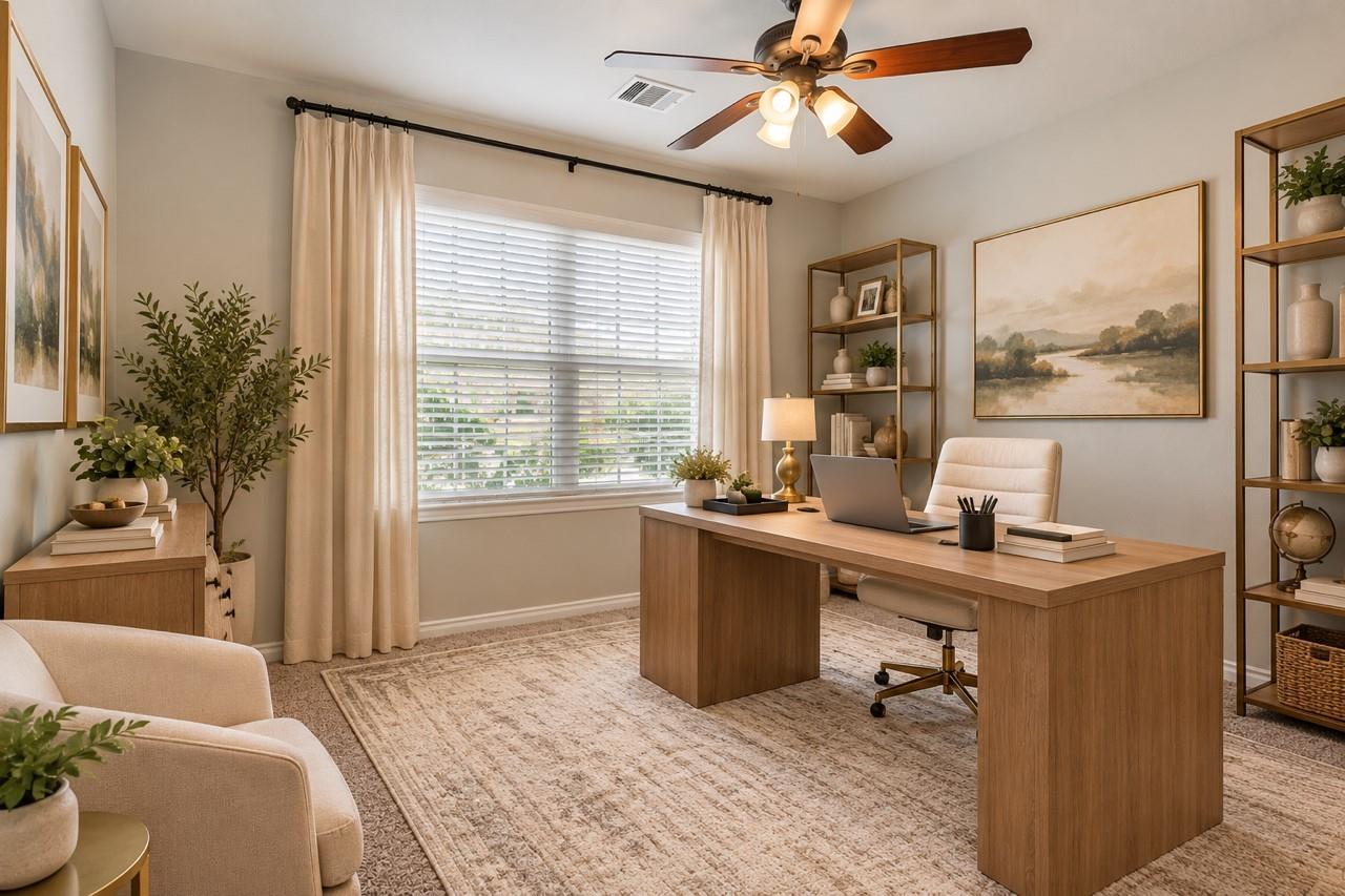 Staged home office with a large wooden desk, window with blinds, and ceiling fan.