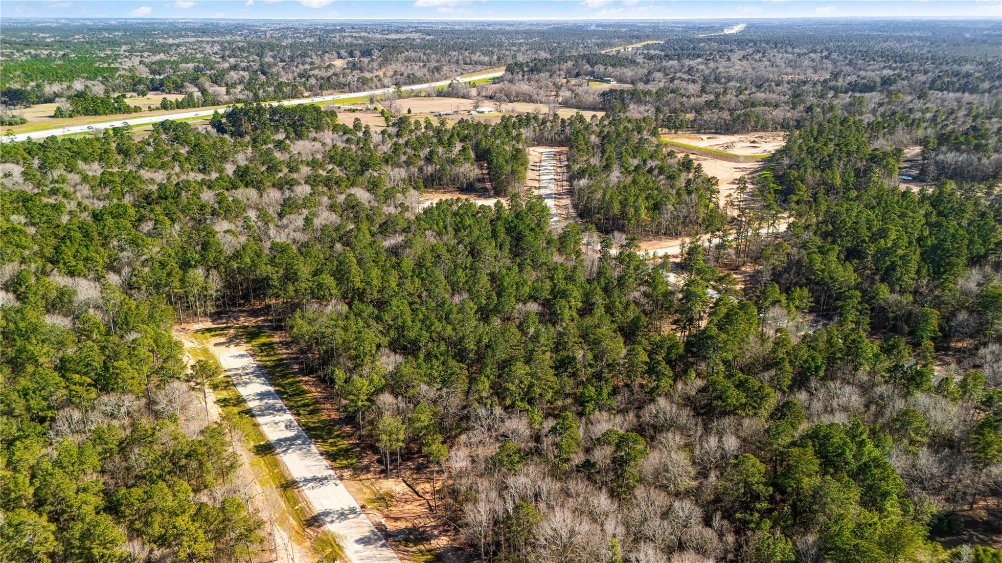 Aerial view of wooded property with newly cleared roads and construction areas.