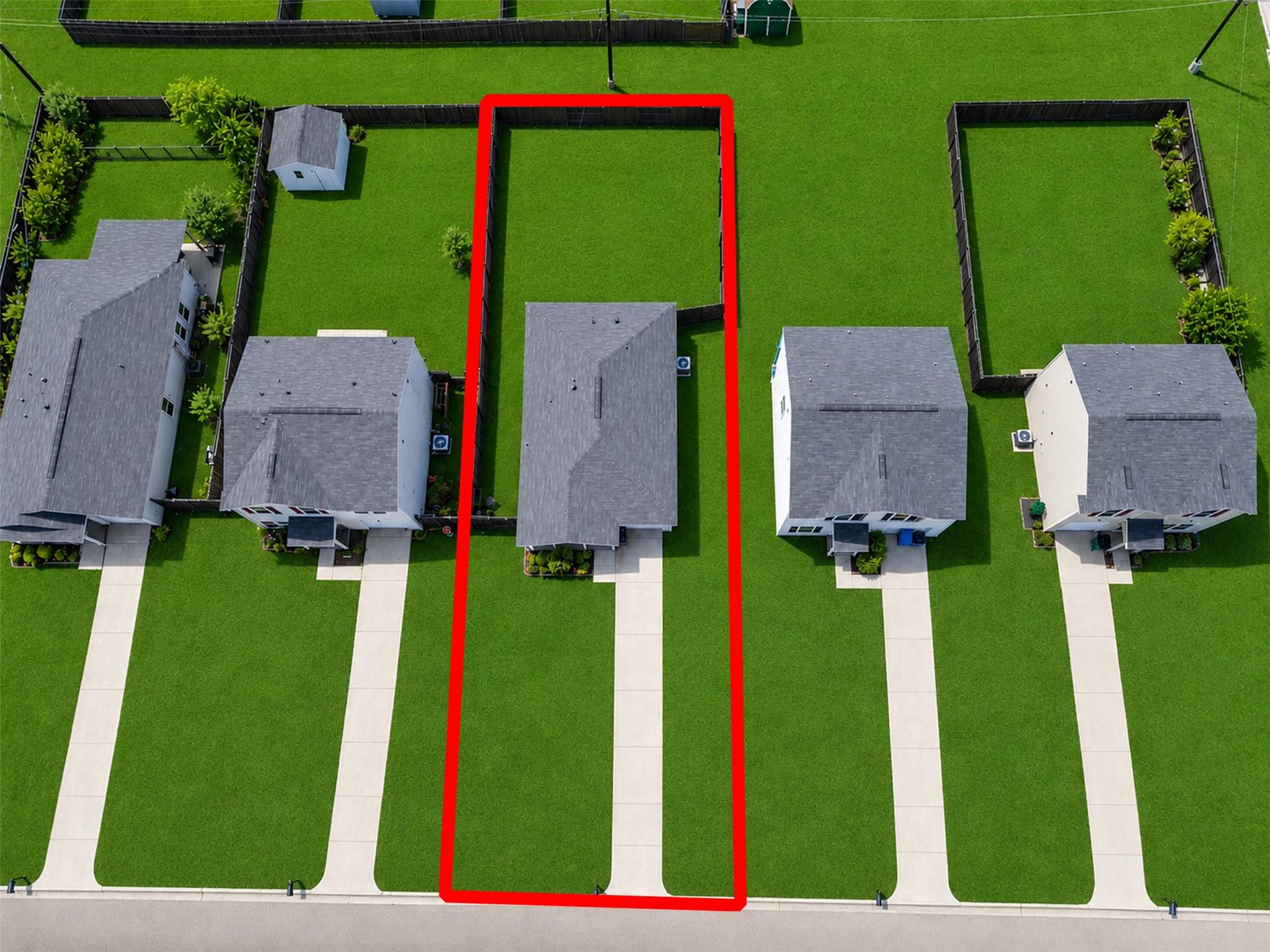 Aerial view of a house and lot outlined in red among neighboring homes.