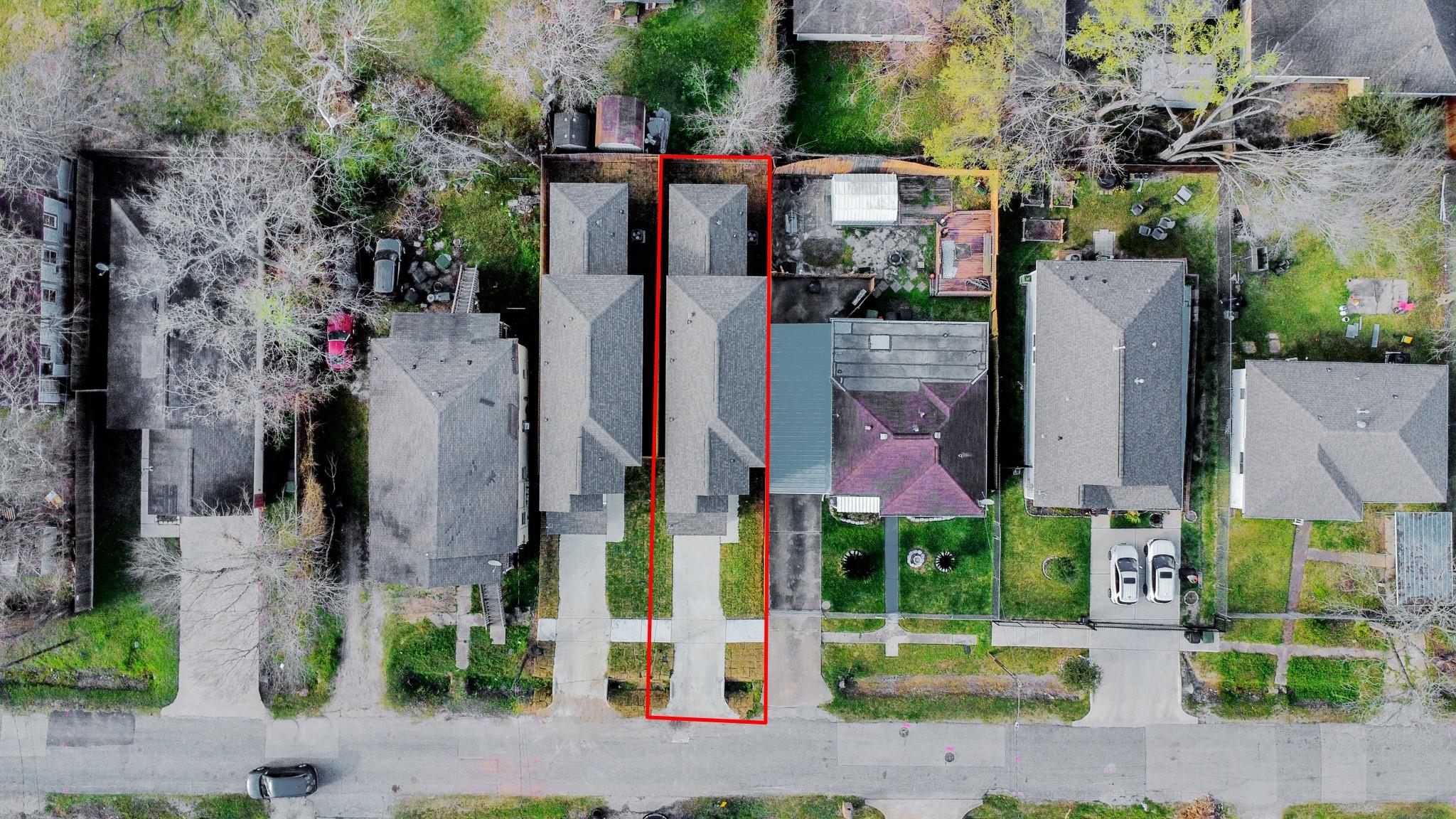 Aerial view of the property outlined in red among neighboring homes.