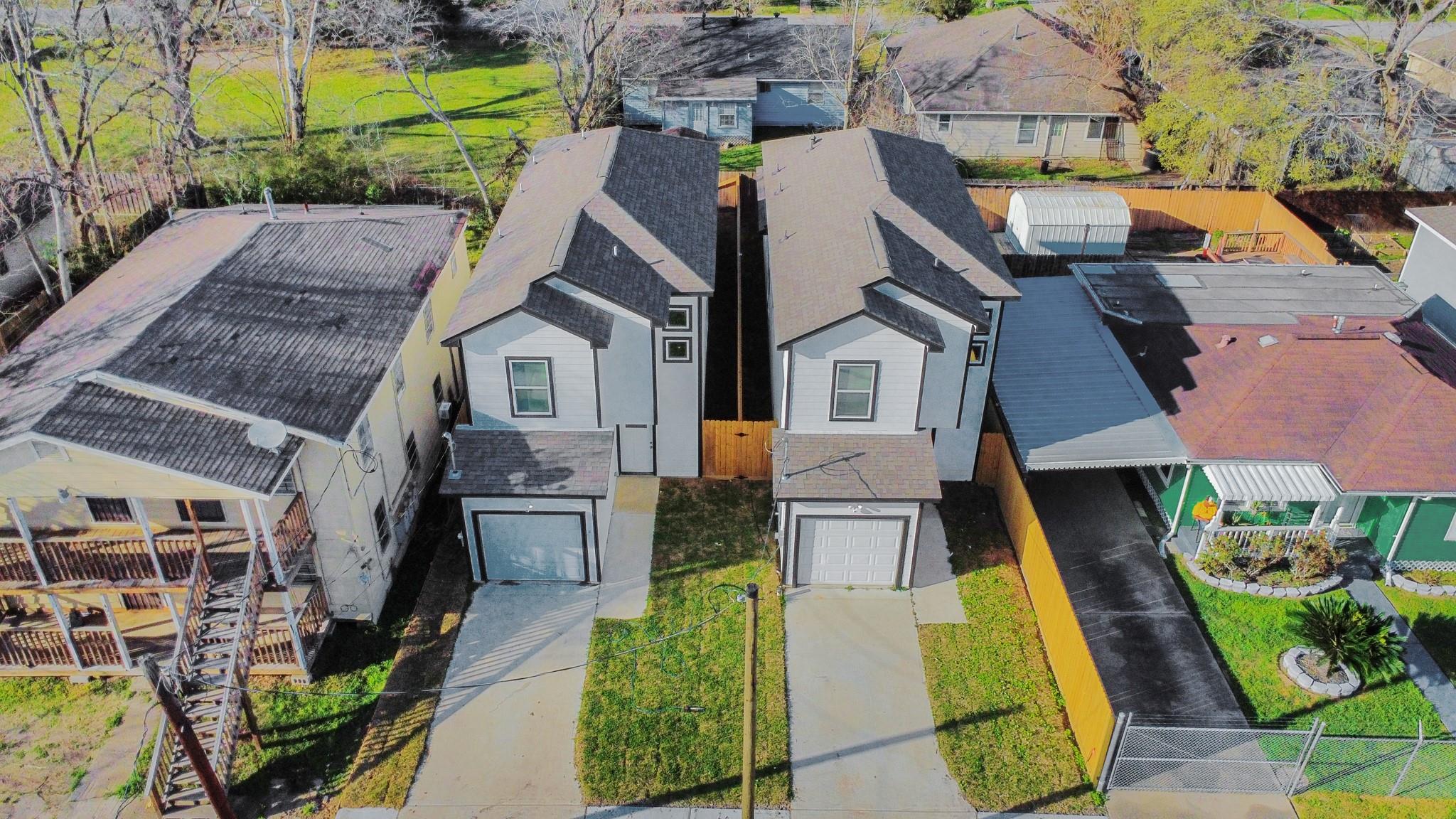 Two modern two-story homes with dark gabled roofs, garages, and separate driveways.