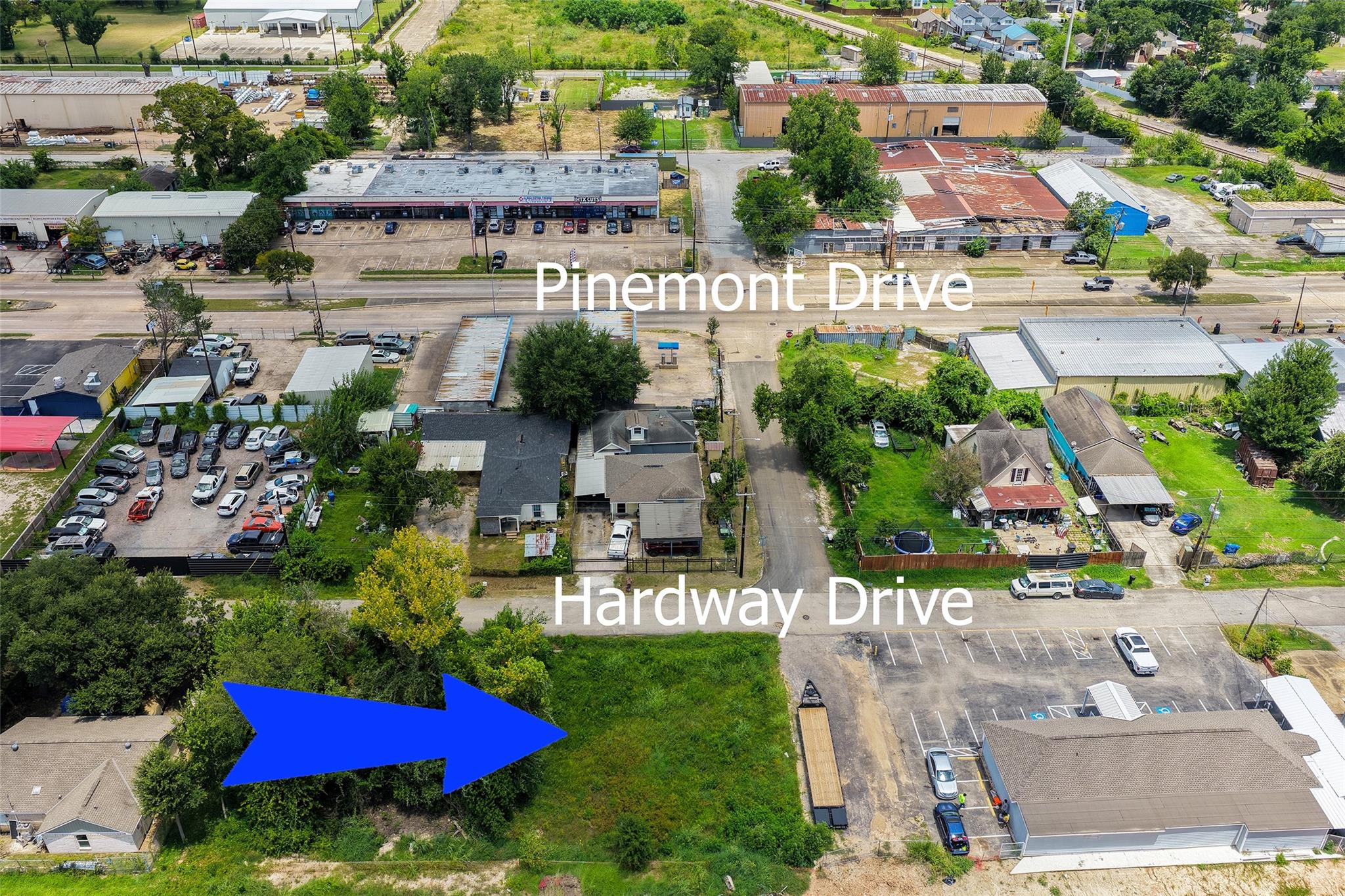 Aerial view of a green lot marked by a blue arrow between Pinemont Drive and Hardway Drive.