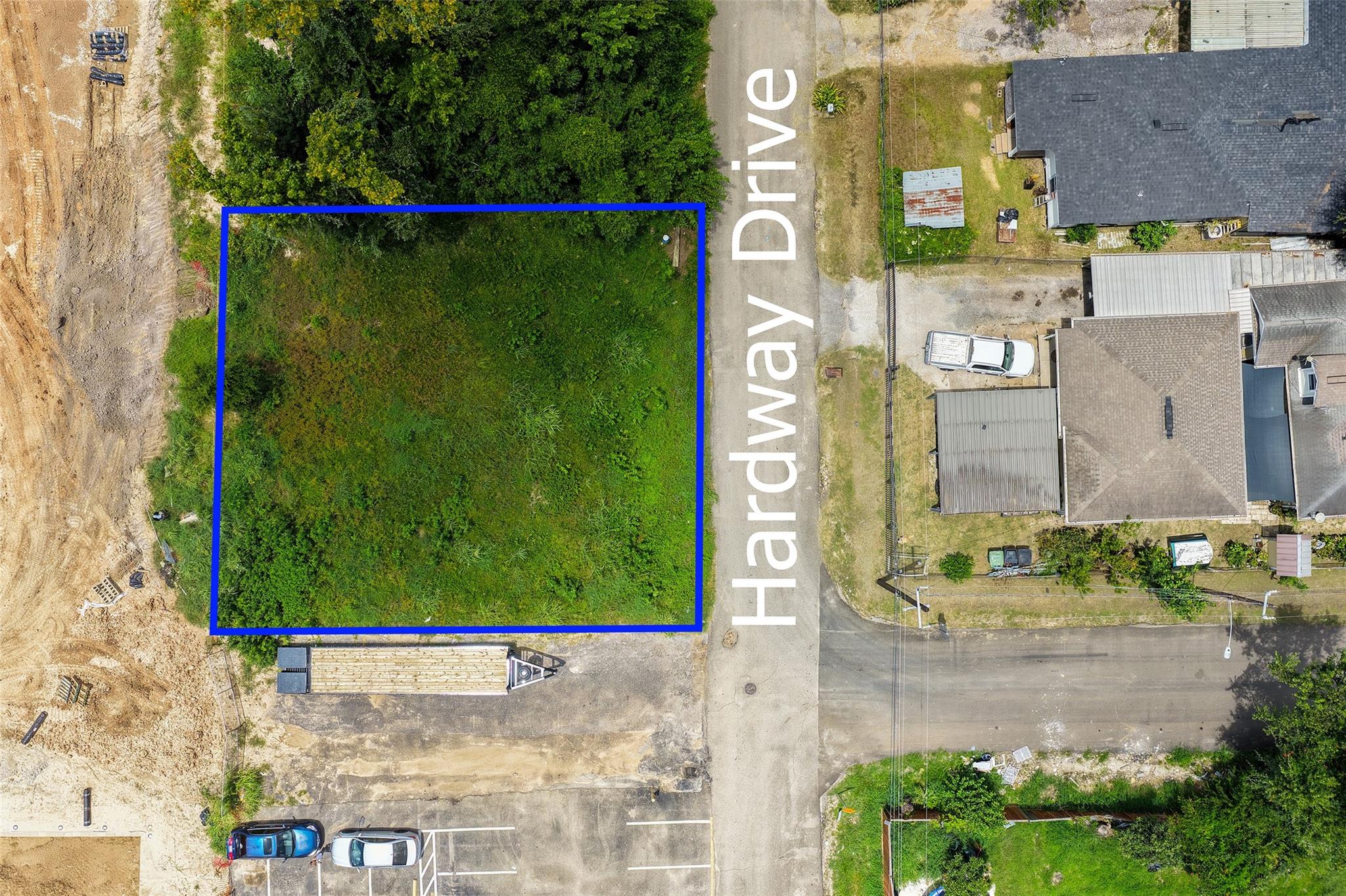 Vacant grassy lot outlined in blue beside Hardway Drive, viewed from above.