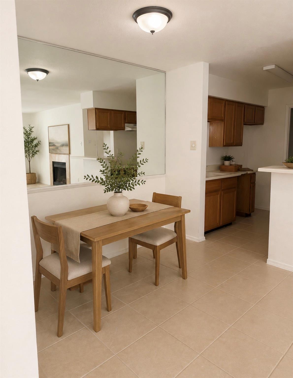 Dining area with a wooden table and chairs beside a kitchen with dark wood cabinets.