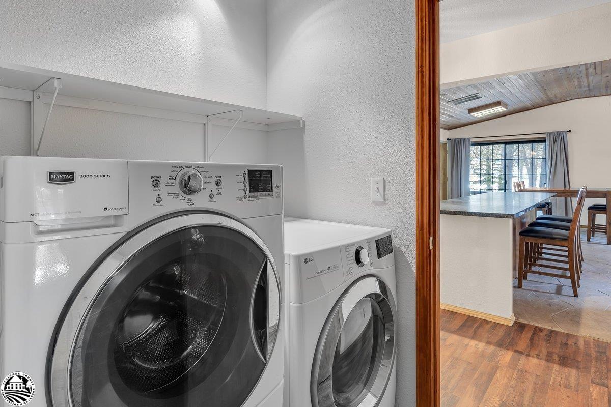 Laundry room with Maytag washer and LG dryer, opening onto a kitchen island and dining area.