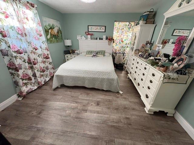 Bedroom with a white bed, pale green walls, floral curtains, and ornate white dressers.