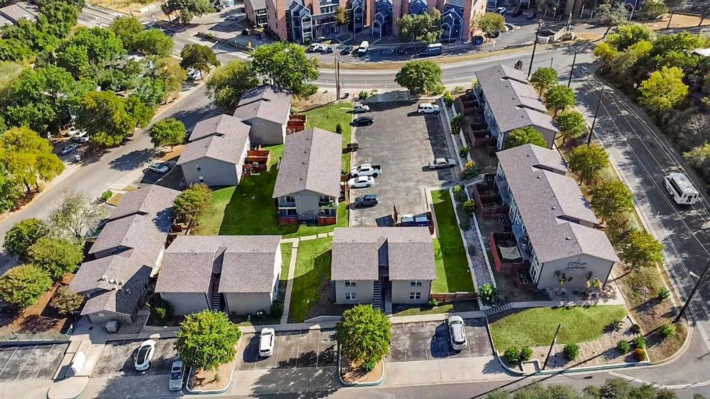 Aerial view of a condominium complex with landscaped grounds and central parking lot.