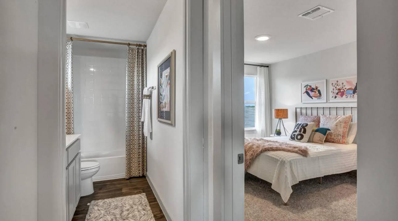 Bedroom and bathroom, with a white bed and patterned shower curtain.