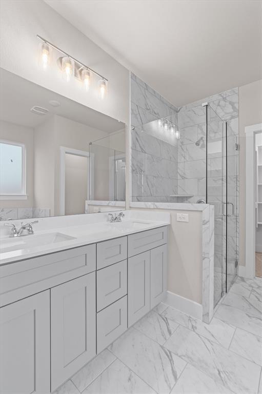 Bathroom with a long double-sink vanity and glass-enclosed marble-look shower.