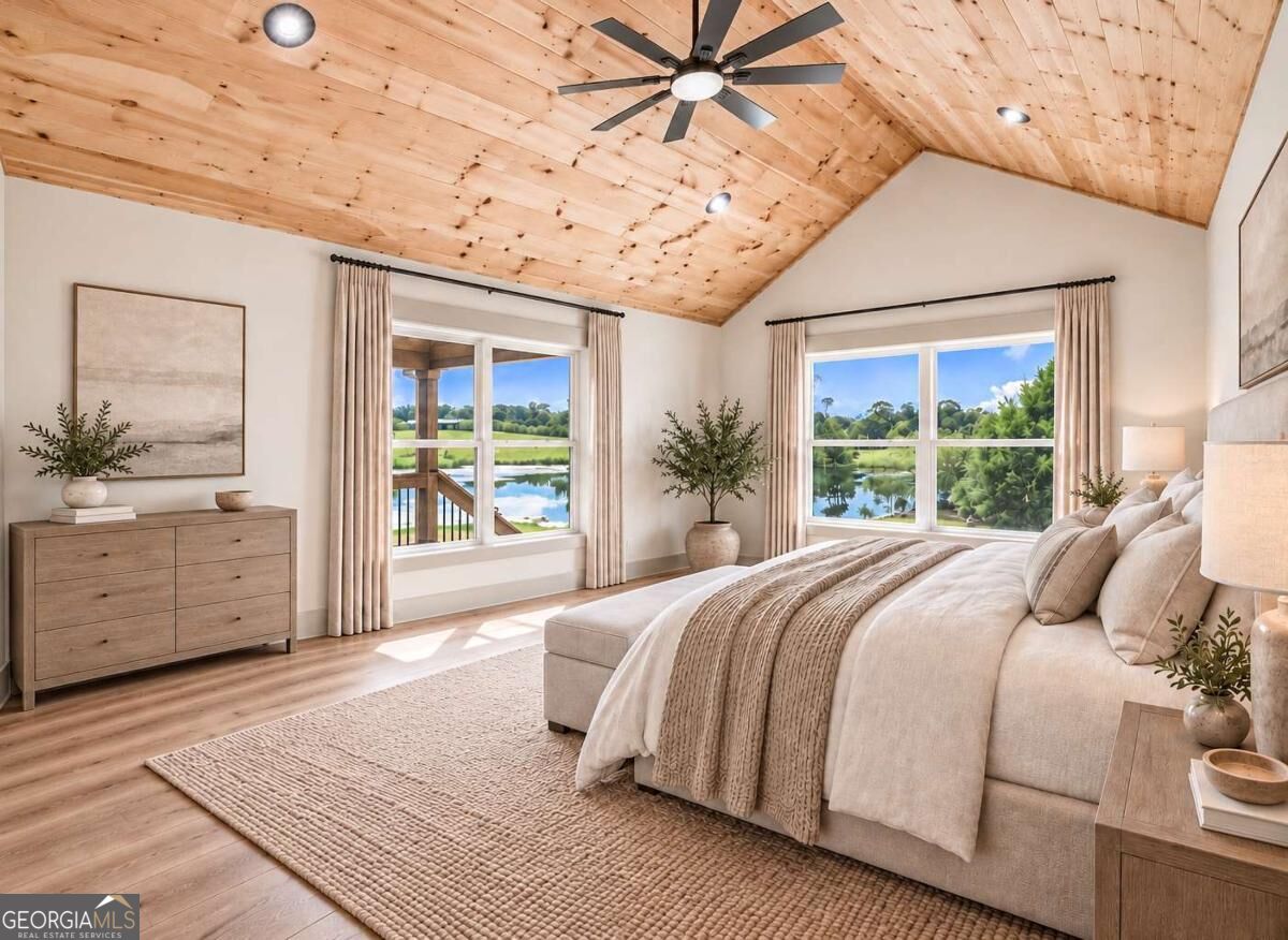 Bedroom with a vaulted wood ceiling, large lake-view windows, and a neutral upholstered bed.
