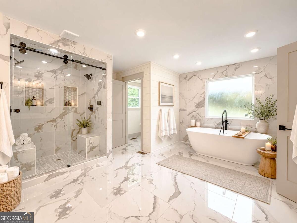 Bathroom with a freestanding soaking tub, glass walk-in shower, and dramatic gray-veined marble-look tile.
