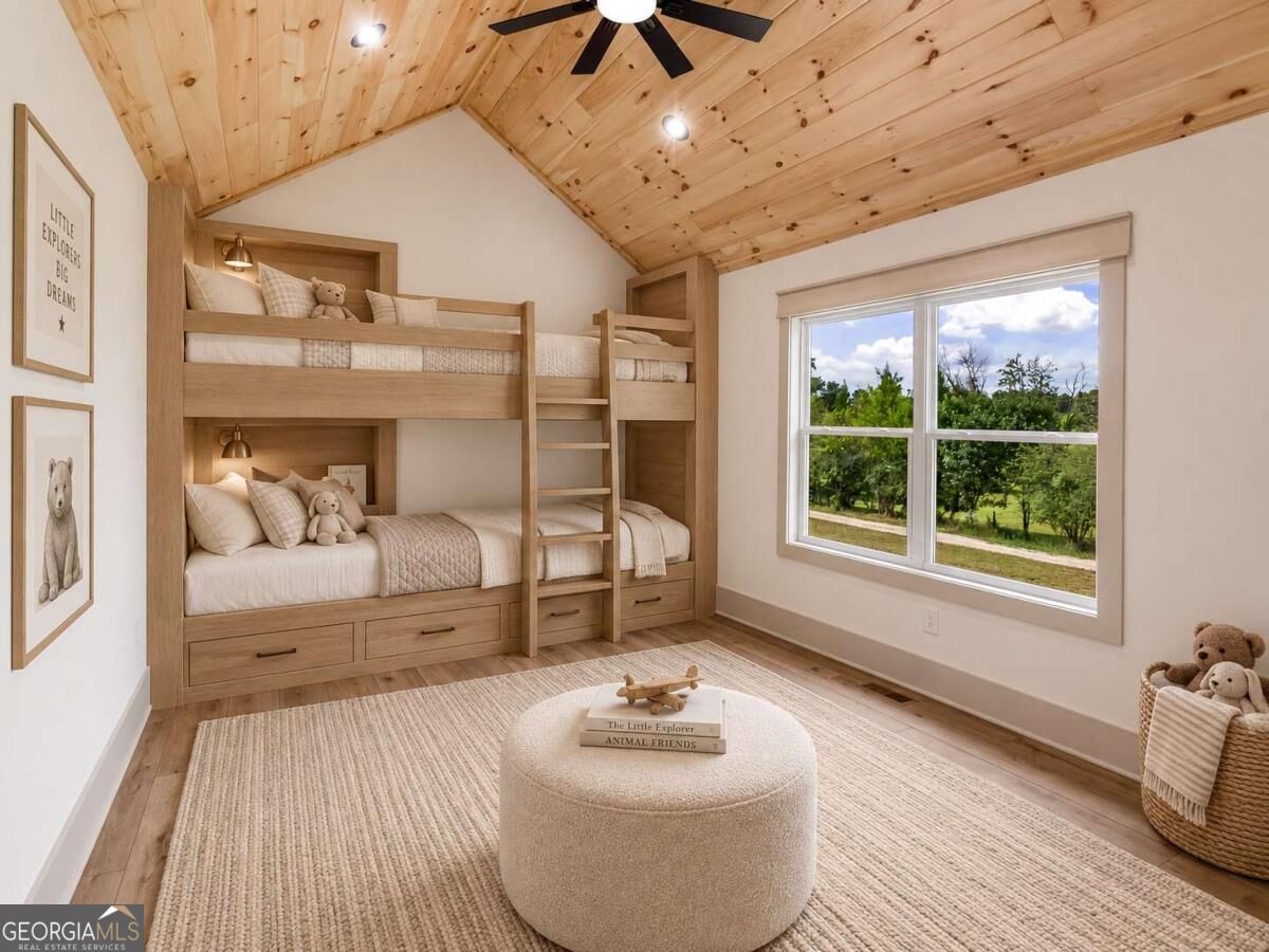 Bedroom with built-in wooden bunk beds, vaulted wood ceiling, and large window overlooking greenery.